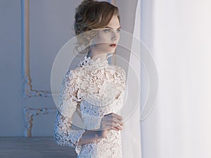 Woman in lace dress at the window