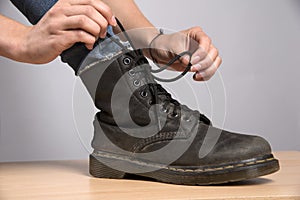 Woman lacing up a black boot