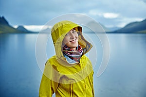 Woman on the Lake coast with mountain reflection, Iceland