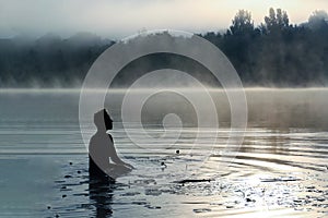 The woman on the lake, at dawn in the fog