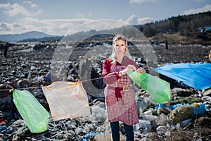 Woman on landfill, consumerism versus plastic pollution concept.