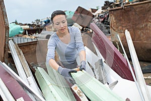 Woman landfill employee working in skip