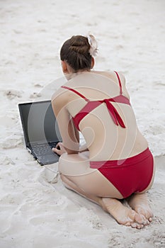 Woman with laptop on the beach