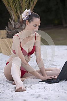 Woman with laptop on the beach