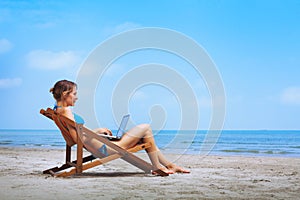 Woman with laptop on the beach