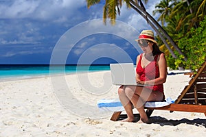 Woman with laptop on beach vacation