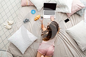 Woman with laptop on the bed