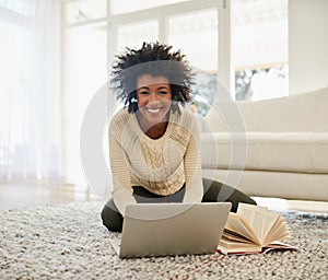 Woman, laptop and book in home on floor, social media and typing or browse for online shopping or networking photo
