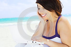 Woman with laptop computer on the beach