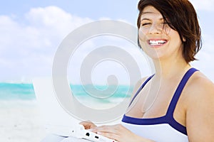 Woman with laptop computer on the beach