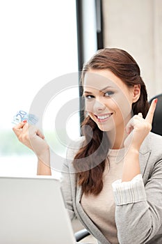 Woman with laptop computer and euro cash money