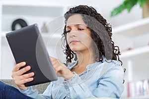 woman with laptop computer sitting on sofa at home