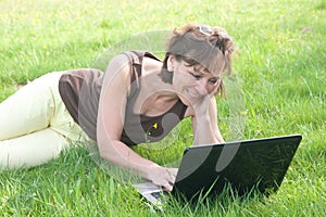 Woman with laptop on field