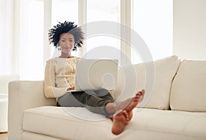 Woman, laptop and happy in home on sofa, social media and typing or browse for online shopping or networking photo