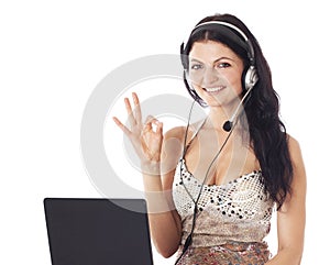 Woman with laptop and headset showing ok sign