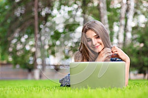 Woman with laptop at home happy showing love with hands in heart shape