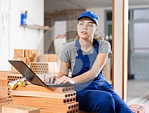 Woman with laptop on indoor construction site