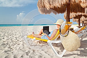 Woman with laptop relaxing on the deckchair