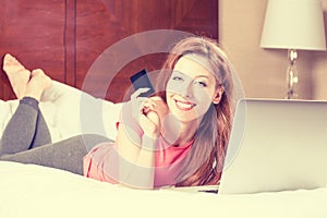 Woman with laptop shopping on line showing credit card