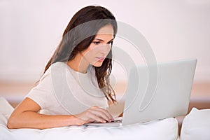 Woman, laptop and typing on sofa for remote work from home with thinking, idea or writing article. Person, girl or