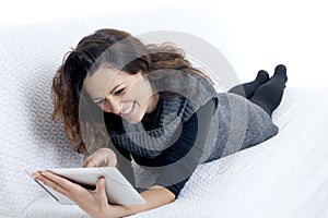 Woman with laptop on white sheet in her bed