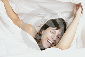 Woman laugh in feather bed