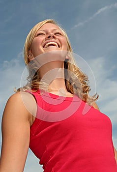 Woman laughing against blue sky