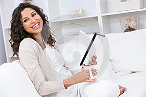 Woman Laughing Drinking Tea or Coffee Using Tablet Computer