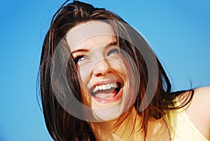 Woman laughing in front of blue sky