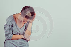 Woman laughing leaning down isolated green grey background wall. Casual grey shirt short hair, brunette girl.  LOL, ROFL. Positive photo