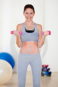 Woman, laughing or portrait with dumbbell in gym for health wellness, fitness or weight loss in training. Young person