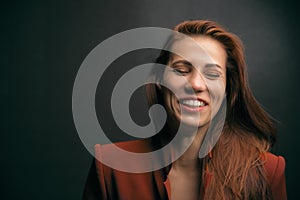 Woman laughing, smiling and happy on a dark background