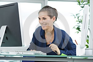 woman laughing while using desktop computer