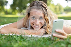 Woman laughing while using smart phone in park