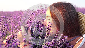 Woman in lavender field - Happy Lady in hat enjoys sunny day, wandering in lavender field, appreciating nature. Girl