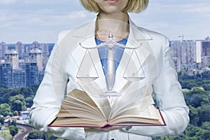 Woman lawer shows the book and scales of justice .