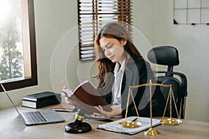 Woman lawyer reading legal book with gavel on table in office. justice and law ,attorney concept