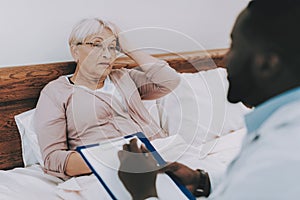 Woman Lay in Bed. Nursing Home. Man with Papers.