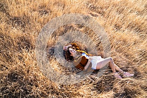 A woman lay down on dried Grass flower in meadow with sun lights