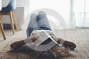 Woman lay down on the floor on carpet sleeping because tired with book to cover eyes. Female people asleep during the day in