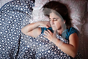 Woman laying in bed with a worried and sad expression - Sickness, depression, anxiety