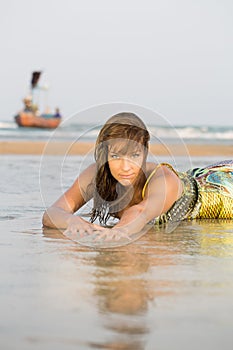 Woman laying down on a sandy beach