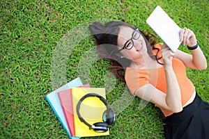 Woman laying on the grass and using the tablet, Education concept, Technology concept