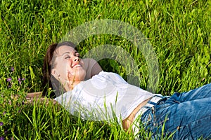 Woman laying on a lawn and is dreaming