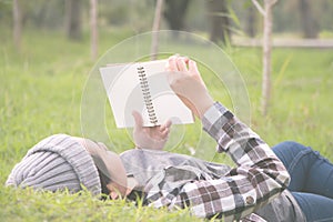 Woman laying and lookin book in a park