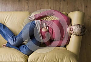 Woman laying on sofa wearing sleep mask