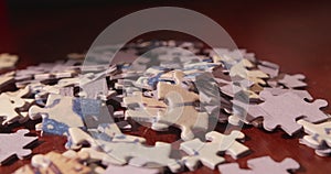 Woman laying some jigsaw puzzle pieces on a wooden table