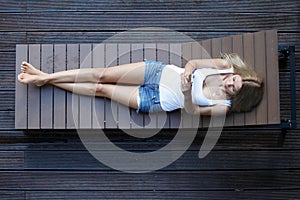 Woman laying on wooden sunbed