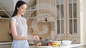 Woman lays out fruits in eco bags in the kitchen. Eco-bags and environmental ecology