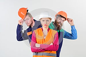 Woman, leader in hard hat with serious face stand